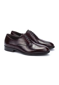 Chaussures en cuir bordeaux à lacets avec une finition lisse, design à bout capé et semelle en caoutchouc basse. Logo accentué sur le côté extérieur.