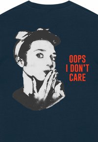 Marine t-shirt met een grafische afbeelding van een vrouw in zwart-wit, met een hand voor haar mond en de tekst "OOPS I DON’T CARE" in vet rood.