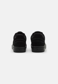 Sneakers nere in suede con una finitura testurizzata, dotate di un collare imbottito, un tassello sul tallone e una suola in gomma nera con logo.