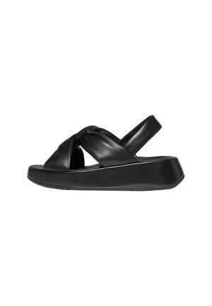Svarta lädersandaler med en tjock plattformssula, med korsade remmar och en ankelrem för en säker passform. Slät yta genom hela sandalen.