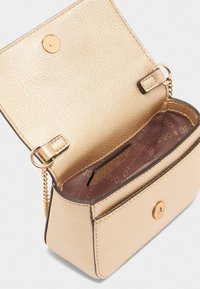 Pochette en texture dorée avec une fermeture à pression magnétique. L'intérieur présente une doublure lisse et une petite fente pour cartes. Chaîne attachée.