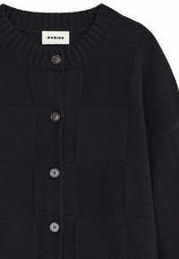 Zwarte gebreide cardigan met een textuur en een geruit patroon, ronde ribgebreide halslijn en drie donkere knopen aan de voorkant.