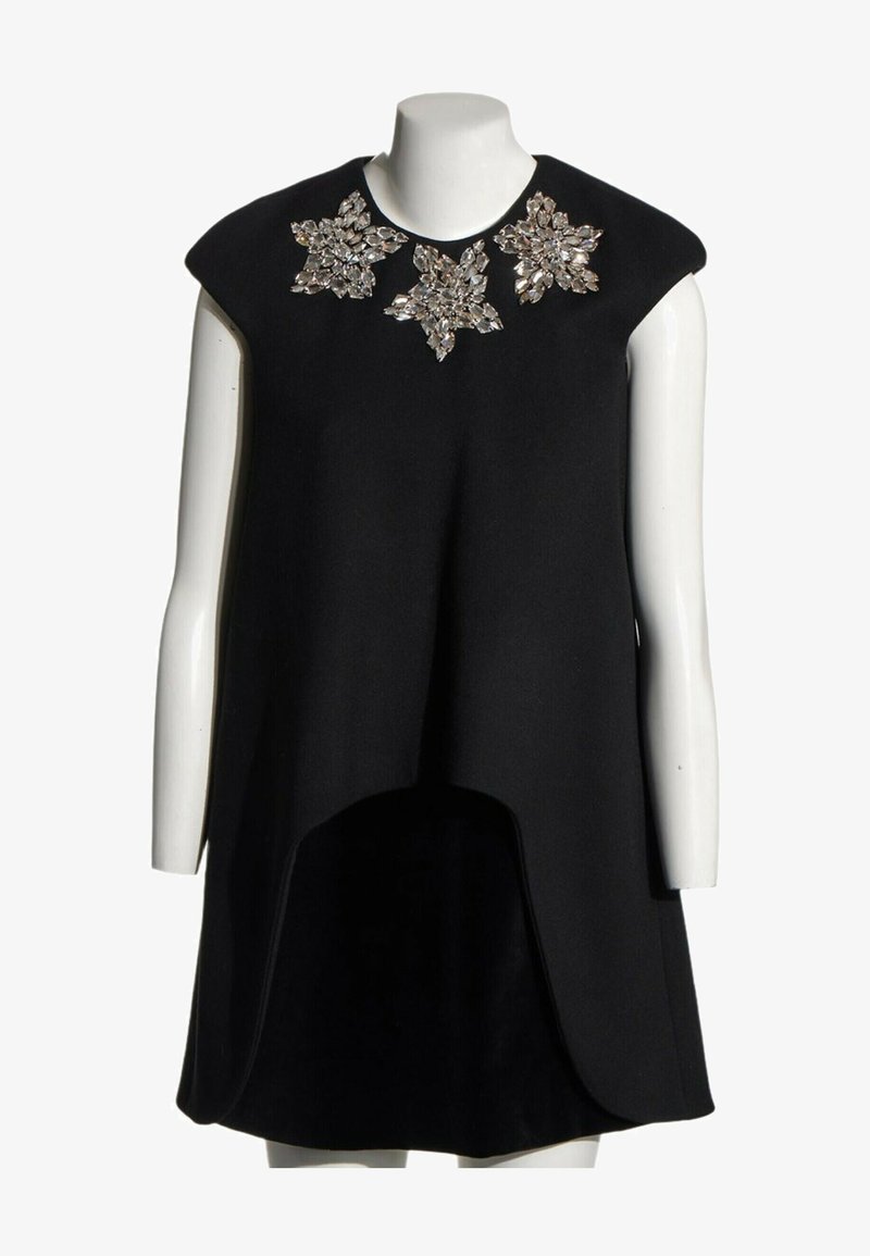 Robe noire sans manches avec un ourlet dégradé et trois grandes embellissements floraux en cristal au niveau de l'encolure sur un mannequin blanc.