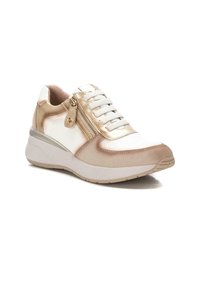 Zapatilla con parte superior en beige y blanco, con un detalle metálico dorado y cremallera, puntera redonda y suela blanca elevada. Diseño con cordones.