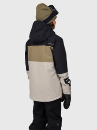 Persona che indossa un giubbotto invernale color block nero, beige e oliva, pantaloni neri, guanti neri, berretto oliva e occhiali da sci, girata di spalle.