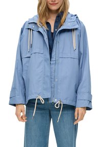 Veste imperméable bleu clair avec capuche, fermeture éclair à l'avant, taille à cordon de serrage et deux poches plaquées, dotée d'une coupe décontractée et d'un tissu texturé.