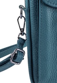 Turkooizen leren tas met een gestructureerde afwerking, voorzien van een zilverkleurige sluiting en een verstelbare riem met gedetailleerd stiksel.