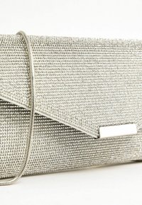 Borsa a pochette argento rivestita di piccoli strass con una sottile tracolla metallica e un fermo rettangolare su sfondo bianco.