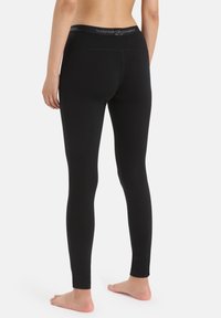 Black leggings with a smooth texture, high waistband featuring the brand name, and a fitted design extending to the ankles.