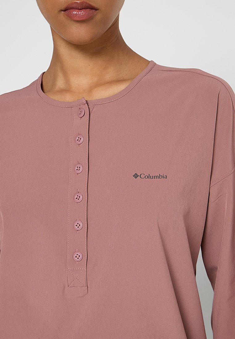 Shirt z długim rękawem w kolorze mauve, z okrągłym dekoltem, z zapięciem na guziki i logo Columbia po lewej stronie. Miękka tkanina o gładkiej fakturze.