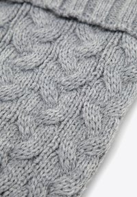 Šedá pletená látka s copánkovým vzorem, obsahující tlustou přízi a strukturovaný povrch, nahoře přeložená pro vytvoření manžety.