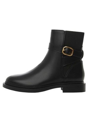 Botte cheville en cuir noir avec bout arrondi, semelle plate, et une bride latérale ornée d'une boucle dorée. Texture lisse et design minimaliste.