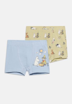 Deux paires de shorty pour enfants, une bleu clair avec un soleil et des personnages assis près d'un feu, l'autre beige avec un motif répétitif de personnages.