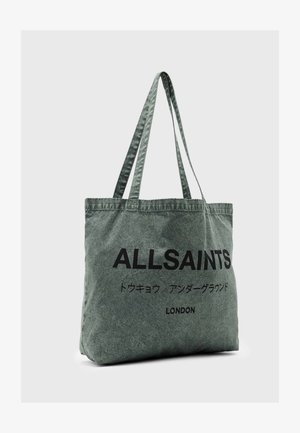 Grijze canvas draagtas met dikke hengsels, voorzien van gedurfde zwarte tekst "ALLSAINTS" en aanvullende tekens. Zachte, gestructureerde oppervlakte.