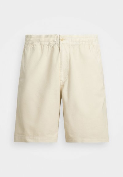 Calções bege claros feitos de um tecido suave, com um elástico na cintura e um fecho de botão único. Design simples, sem padrões.