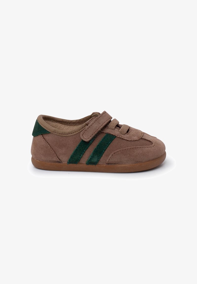 Brown suede shoe with green felt stripes and an adjustable Velcro strap. Rounded toe and soft sole enhance comfort and flexibility.
