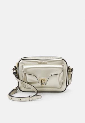 Petit sac bandoulière argenté métallisé avec poche avant, fermoir doré, bordure noire et bandoulière réglable.