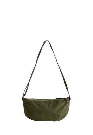 Petit sac bandoulière vert olive avec bandoulière réglable et fermeture éclair sur le dessus sur fond blanc.