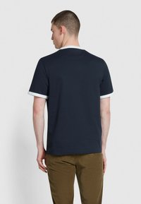 T-shirt blu navy con maniche corte, caratterizzato da un bordo bianco a contrasto al colletto e all'orlo delle maniche. Tessuto liscio e leggero.