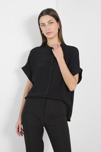 Maglietta nera a maniche corte realizzata in un tessuto leggero, con chiusura a bottoni, maniche arrotolate e una vestibilità relaxed con spacchetti laterali.