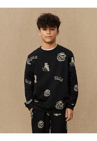 Svart crewneck sweatshirt med Yale-logoer og bulldog-grafikk i beige. Laget av teksturert stoff med ribbestrikkede mansjetter og nederkant.