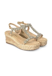 Sandali a zeppa beige con suole in juta intrecciata, design a T, impreziositi da strass metallici sulla parte superiore, dotati di una cinturino regolabile alla caviglia.