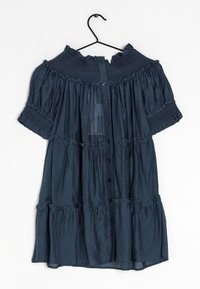 Vestito a balze blu scuro con maniche corte a sbuffo, colletto ondulato, yoke arricciato e polsini, e chiusura con bottoni frontale su una gruccia nera.