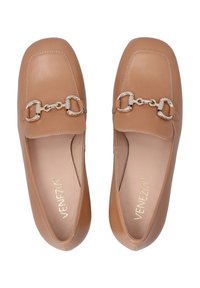 Hellbraune Lederloafers mit flachem Design, die vorne mit einer silbernen Kette verziert sind und feine Stichdetails entlang der Kanten aufweisen.