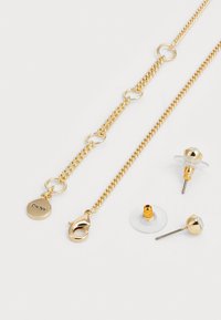 Gold-tone jewelry set featuring a chain necklace with circular links and a lobster clasp, plus two pairs of stud earrings with clear accents.