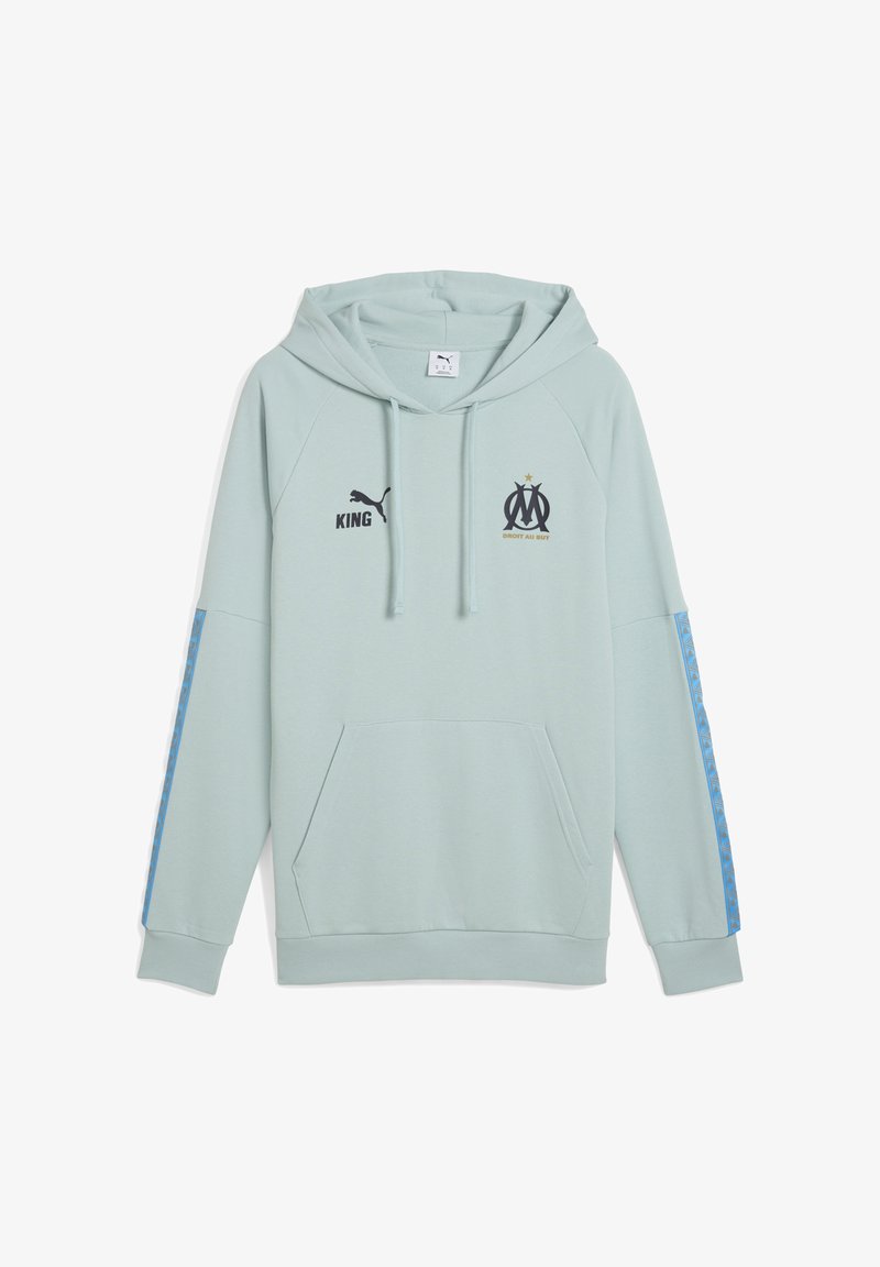 Felpa verde menta chiaro con tasca a canguro. Logo nero "Puma", testo "KING" e simbolo "OM" stampati sul petto. Accenti blu a fantasia sulle maniche.
