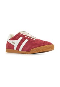 Zapatilla de ante roja con rayas blancas, cordones color crema y una suela de goma texturizada. Logo de Gola en el costado y en la parte superior de la lengüeta. Diseño de perfil bajo.