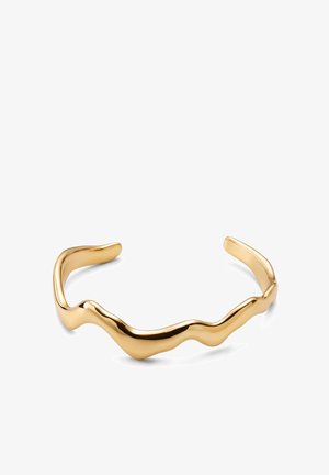 Armband in Goldoptik mit offenem Ende, abstraktem, wellenförmigem Design und glatter, polierter Oberfläche auf weißem Hintergrund.