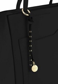 Sac fourre-tout noir avec un matériau lisse, un design structuré, des accents en métal doré, une anse en cuir noué et une étiquette en forme de rond.