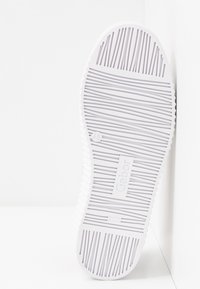 Semelle de chaussure blanche avec rainures horizontales et verticales texturées, étiquette de taille 4½, nom de marque « Gabor » et inscription « Made in Slovakia ».