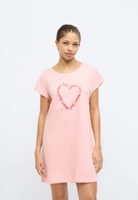 Ροζ βαμβακερό φόρεμα με άνετ η εφαρμογή, κοντά μανίκια και καμπυλωτή λαιμόκοψη. Διακοσμημένο με κόκκινα γράμματα σε σχήμα καρδιάς που λένε «amore love» επανειλημμένα.