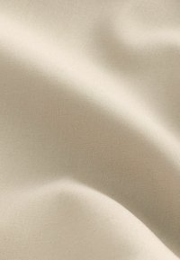 Țesătură bej cu o textură netedă și un model de țesătură subtil, prezentând pliuri fine și o ușoară strălucire sub diferite lumini.