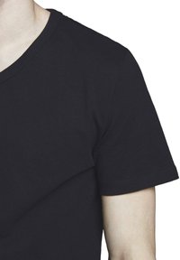 T-shirt di cotone nero con collo a giro, maniche corte e texture morbida. Dettaglio di cucitura visibile attorno al collo.