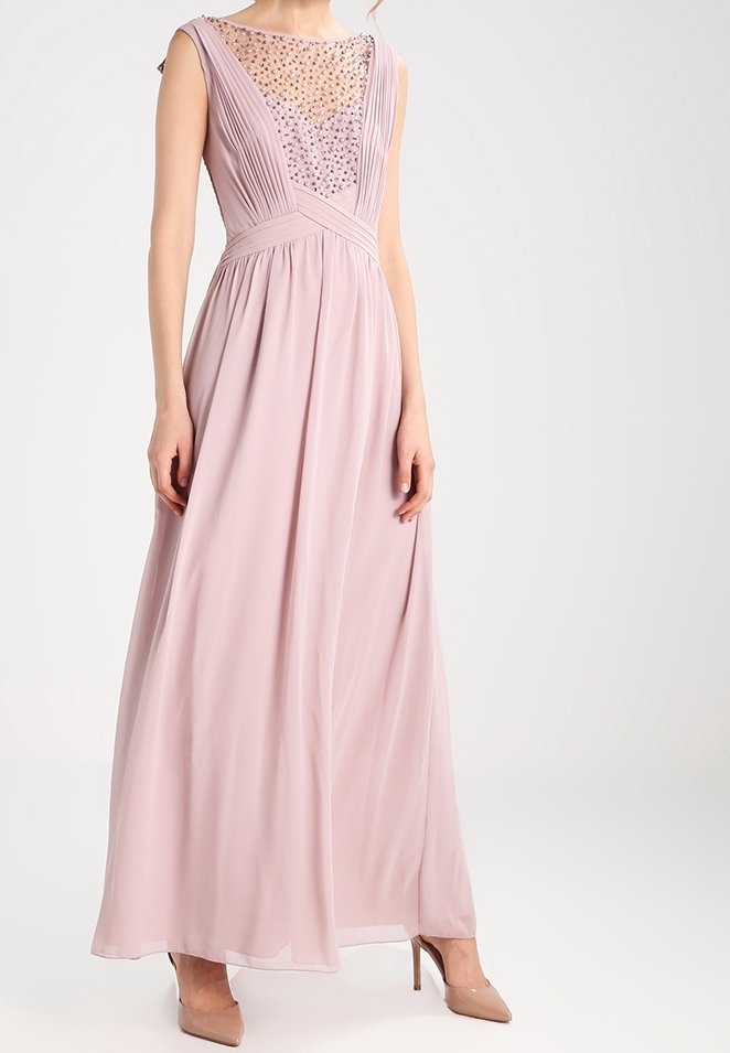 Dlouhé růžové šifónové šaty s plisovaným tělem a korálkovými detaily. Mají kulatý výstřih a splývavou sukni. Kombinují se s nahými vysokými podpatky.