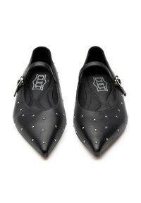 Ballerine nere a punta con piccoli studs argentati e cinturini alla caviglia con fibbie argentate, mostrate affiancate su uno sfondo bianco.