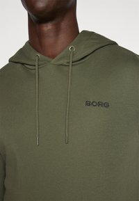 Felpa verde oliva con cappuccio regolabile, caratterizzata da un logo "BORG" nero sul petto e realizzata in un morbido tessuto testurizzato.