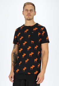 Mustapaitainen t-paita, jossa on koko kankaan kattava oranssi hirvi-kuvio, pyöreä kaula-aukko, lyhyet hihat ja pieni rintatasku. Puuvillamateriaali.