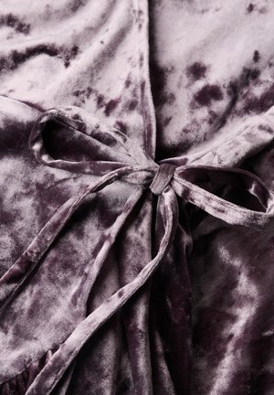 Écharpe en velours violet profond, moelleux, avec une surface douce et texturée, mettant en avant un détail de taille nouée et un subtil motif marbré sur l'ensemble.