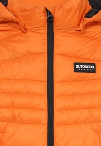 Oranger Puffer-Jacke mit einem schwarzen Reißverschluss. Verfügt über horizontale Nähte und ein Logo-Label auf der Vorderseite. Das Material wirkt glatt und isoliert.