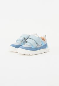 Zapatos de velcro azules con una mezcla de texturas lisas y de gamuza. Presentan detalles en azul claro y una suela de goma blanca. Diseño de punta redonda.