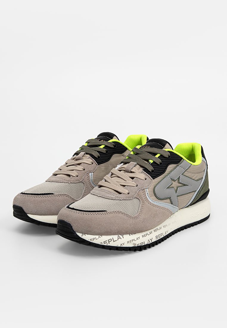 Beige en grijze sneakers van suede en mesh, met zwarte veters, neon groene accenten en een gestructureerde zool met bedrukte branding.