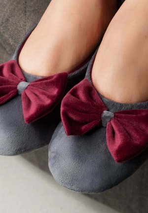 Ballerines en tissu gris avec de jolis nœuds bordeaux en velours à l'avant, offrant une texture douce et un design arrondi pour le confort.