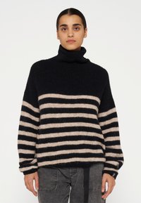 Gestreepte coltrui in zwart en beige, met een losse pasvorm, textuur gebreid en lange mouwen met ribgebreide manchetten.