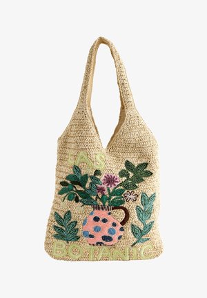 Sac cabas tissé beige avec un vase rose à pois, des feuilles vertes et des fleurs violettes, avec "LAS BOTANIC" brodé en vert clair.