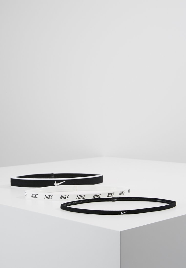 Diademas Nike en blanco y negro, con material elástico y un diseño delgado, con el logo de Nike destacado en ambas.