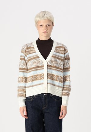 Brown, blue, and cream patterned cardigan with a V-neck, three buttons, and ribbed cuffs. Worn over a dark turtleneck.